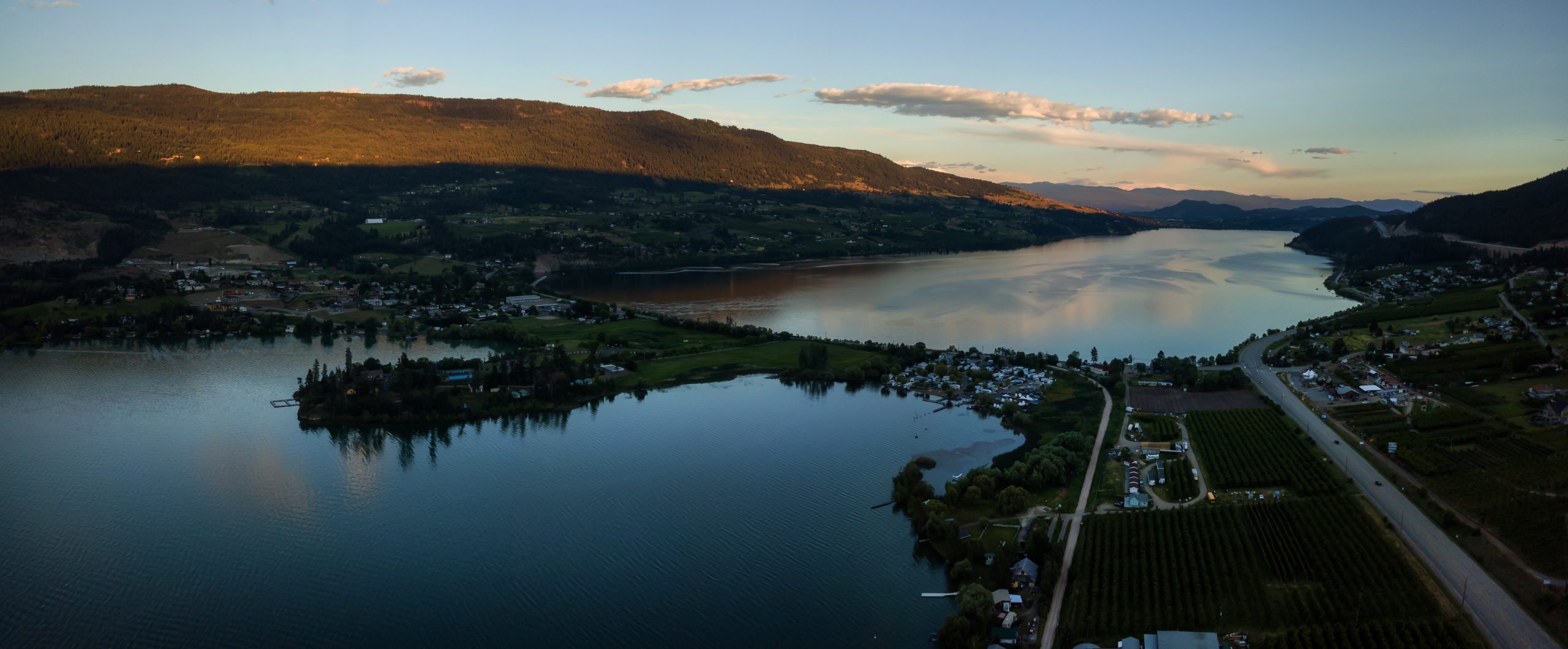 Aerial panoramic view of a small town, Oyama, during a vibrant summer sunset. Located near Kelowna and Vernon, BC, Canada.